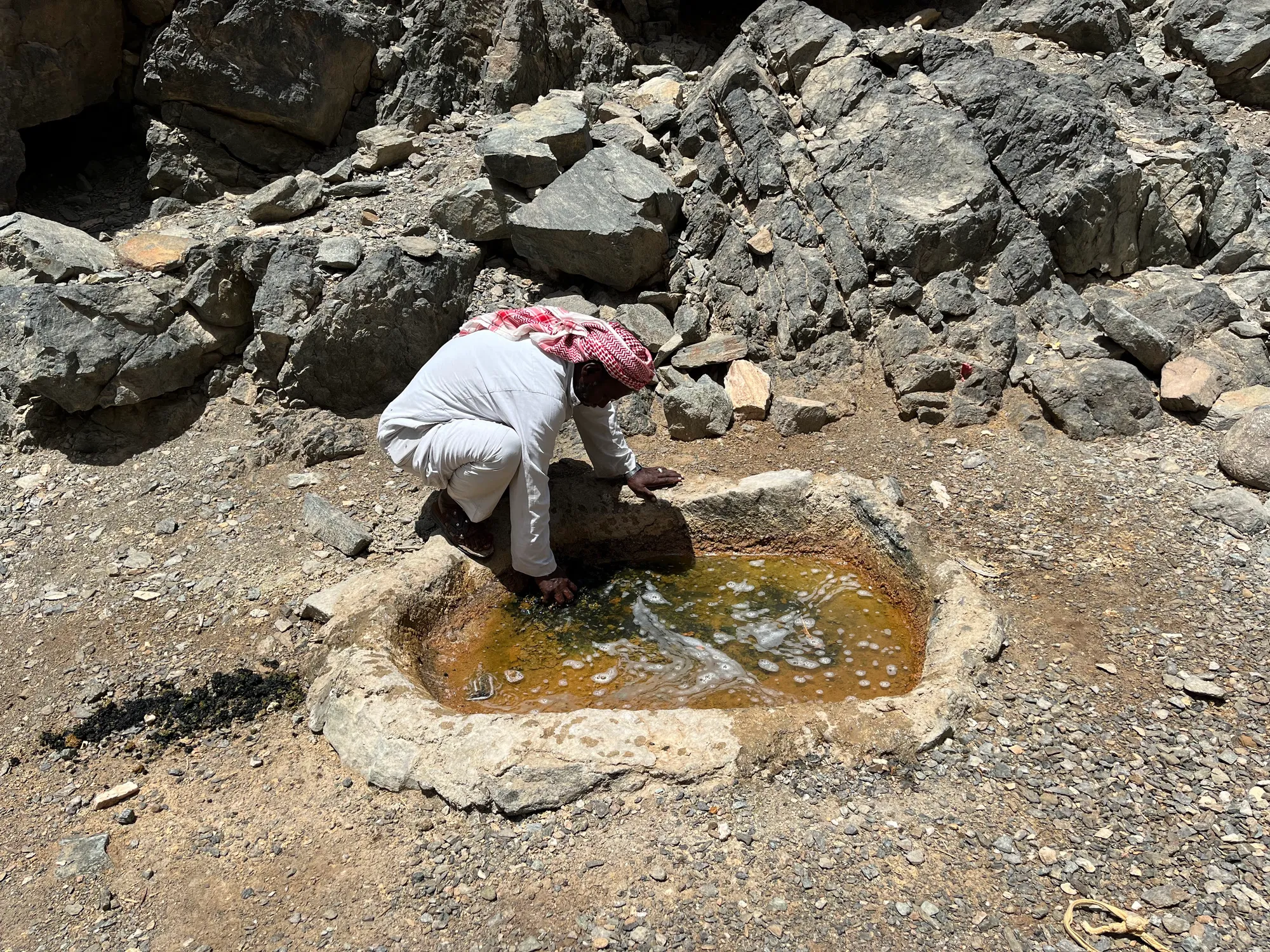 Moustafa demonstrating the water well and filling the reservoir for animals